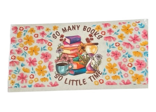 Charming bookish cup wrap with the text "So Many Books, So Little Time" surrounding a stack of colorful books, a teal coffee cup, and an hourglass, all framed by a bright pink and yellow wildflower pattern.