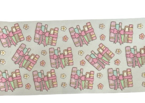 Pattern of pink book stacks with bows and flowers on a clear background