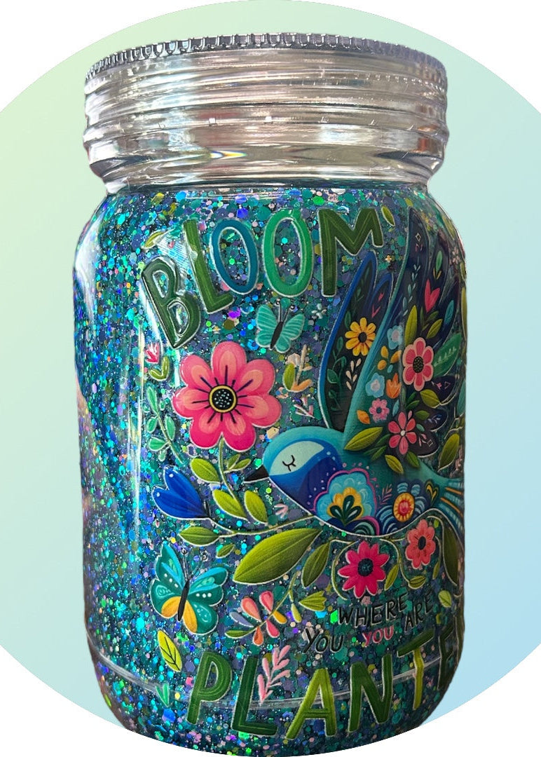 Decorative jar with floral designs and the word 'Bloom' on a light green and blue gradient background
