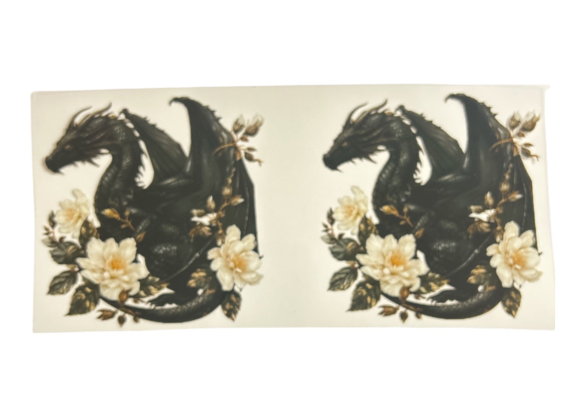 Two black dragons with floral accents on a clear background