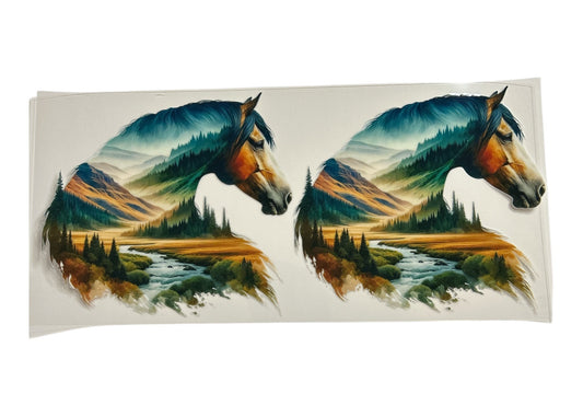 Two horse heads with mountain and forest scenery inside on a clear background