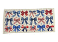 Sheet of red, white, and blue decorative bows on a beige background