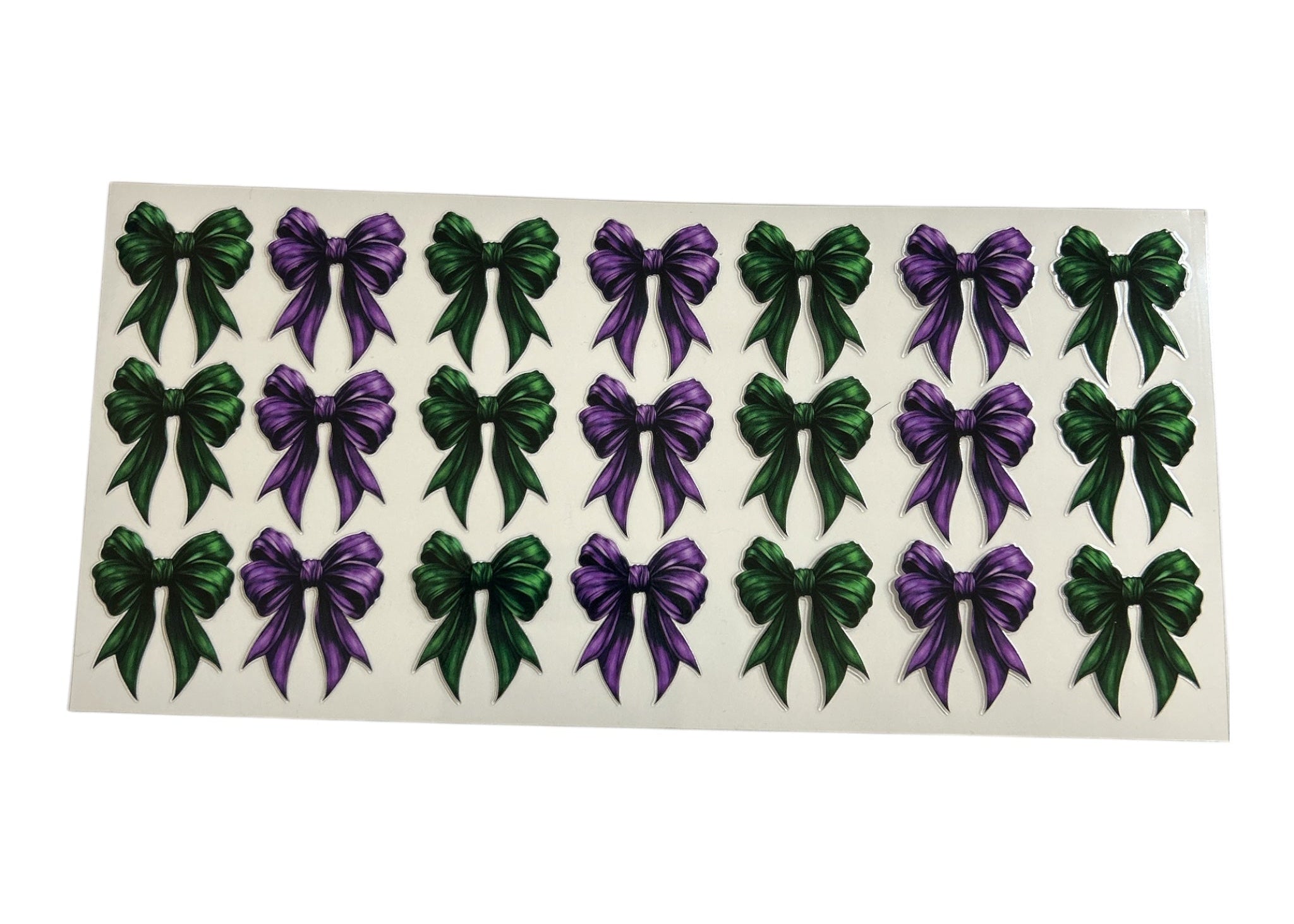 Sheet of green and purple bow stickers on a white background