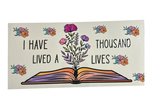 Decorative cup wrap with an open book design, flowers, and text on a white background