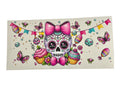 Colorful skull design with pink bow, cupcakes, and butterflies on a white background