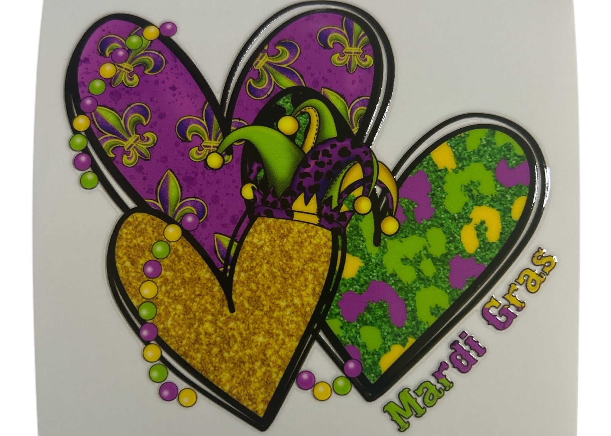 Colorful heart-shaped design with Mardi Gras theme on a white background