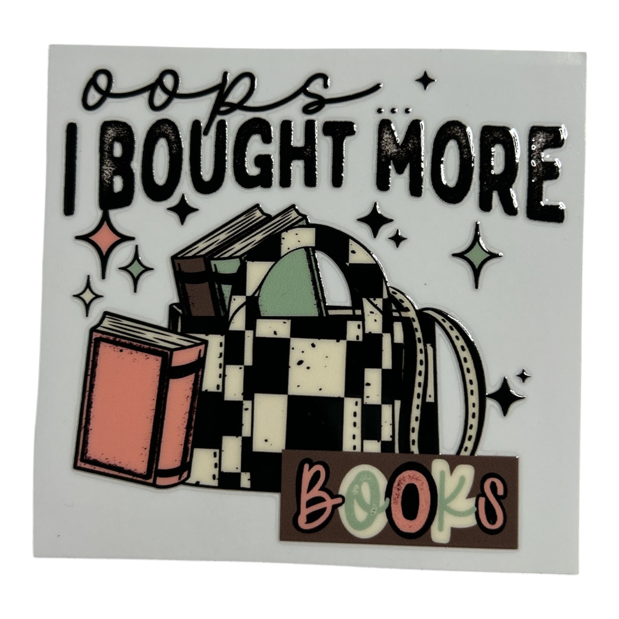 Sticker with text 'oops I bought more books' and a graphic of books and a checkered bag.