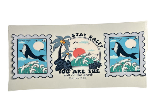 Decorative cup wrap with ocean-themed design featuring whales and palm trees on a clear background and text of a bible verse.