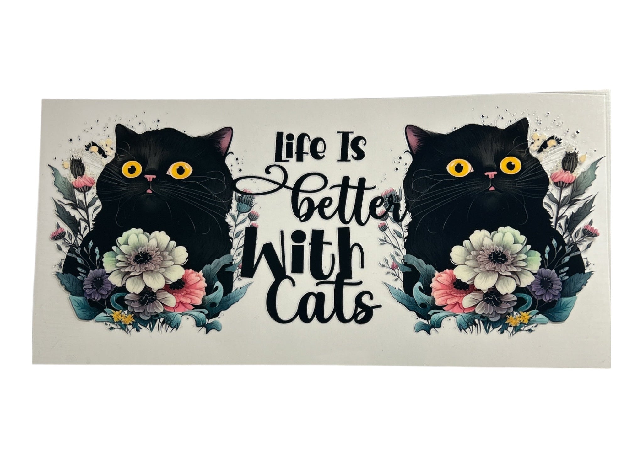 Decorative cup wrap with two black cats surrounded by flowers and the text 'Life is better with cats' on a clear background.