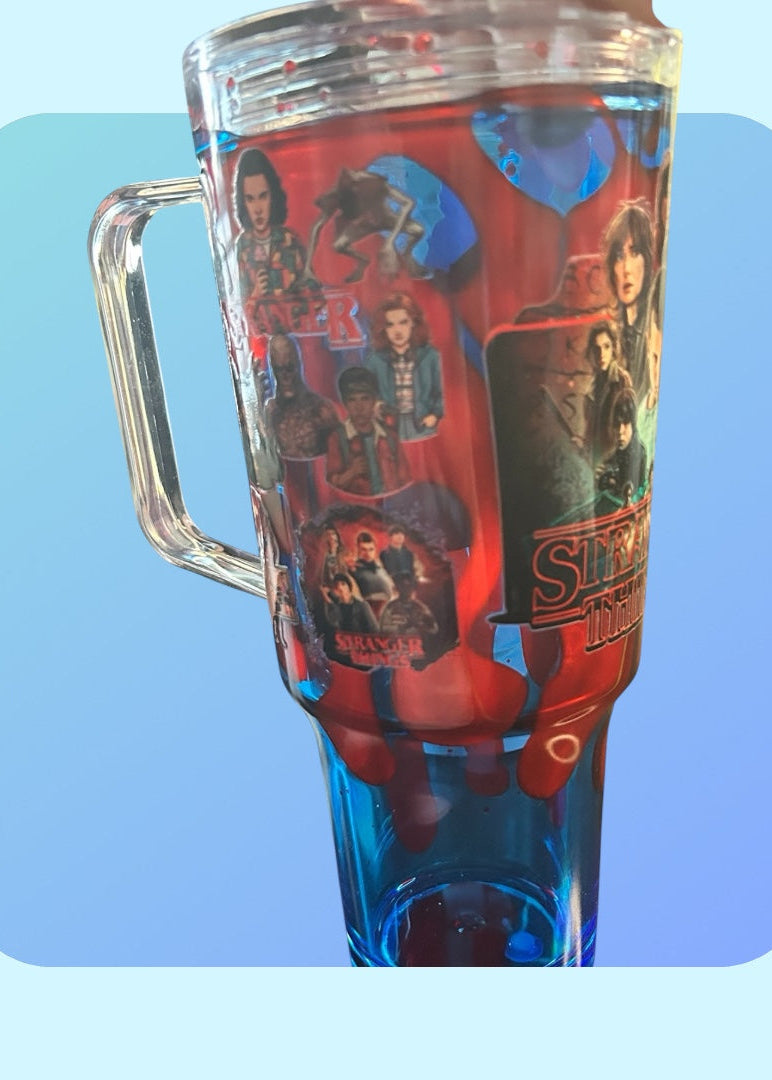 Clear mug with colorful design featuring characters and text on a light blue background