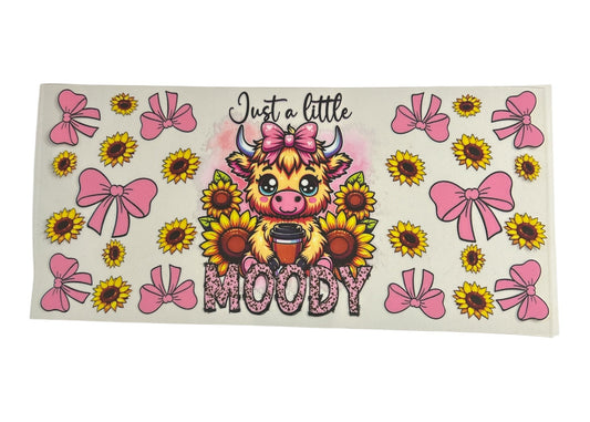 Sticker with a cartoon cow, sunflowers, and pink bows on a white background