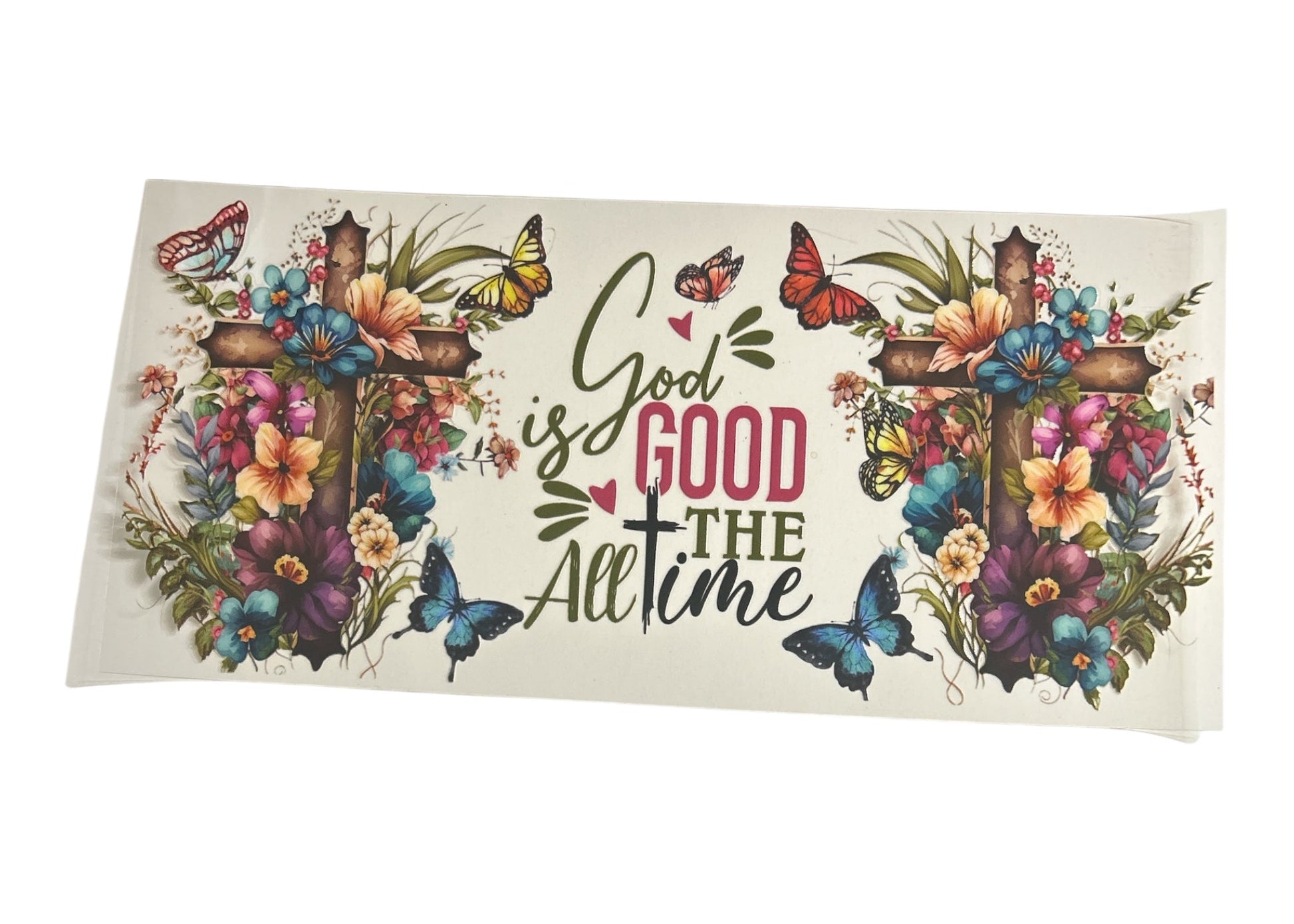 Decorative cup wrap with floral designs, crosses, and butterflies with text 'God is Good All the Time' on a white background.