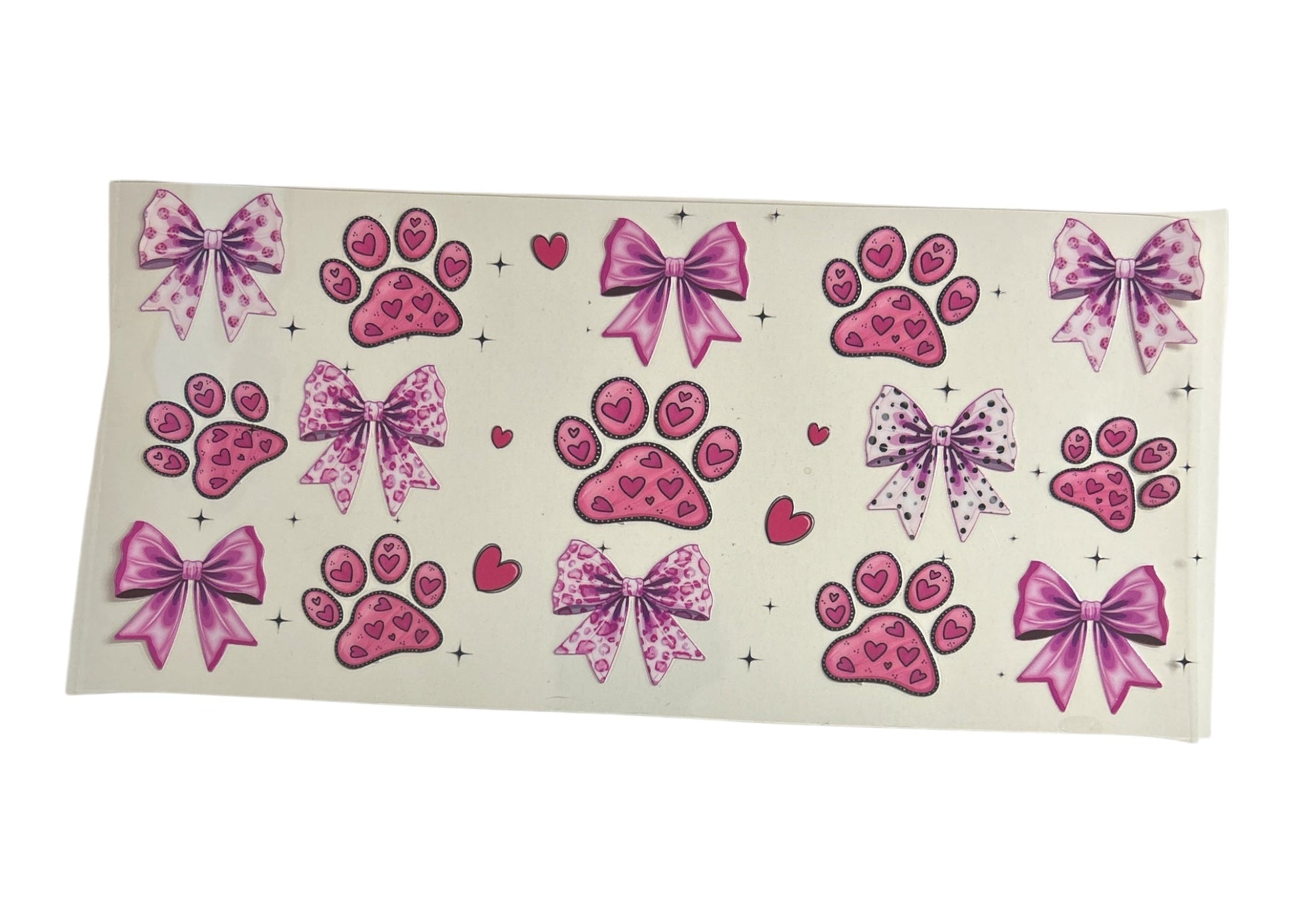 Sheet of pink paw print and bow designs on a clear background