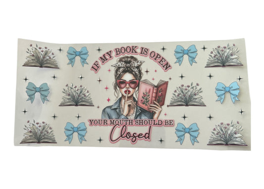 Cup wrap with a design of a woman reading a book and text 'If my book is open, your mouth should be closed' on a white background.