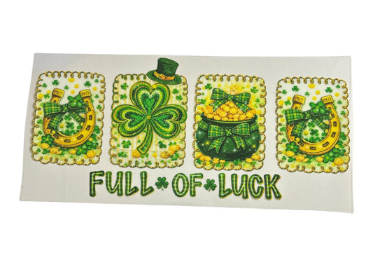 St. Patrick's Day cup wrap featuring four scalloped decorative panels with golden horseshoes, a leprechaun-hatted shamrock, and a pot of gold, above the text "FULL OF LUCK."