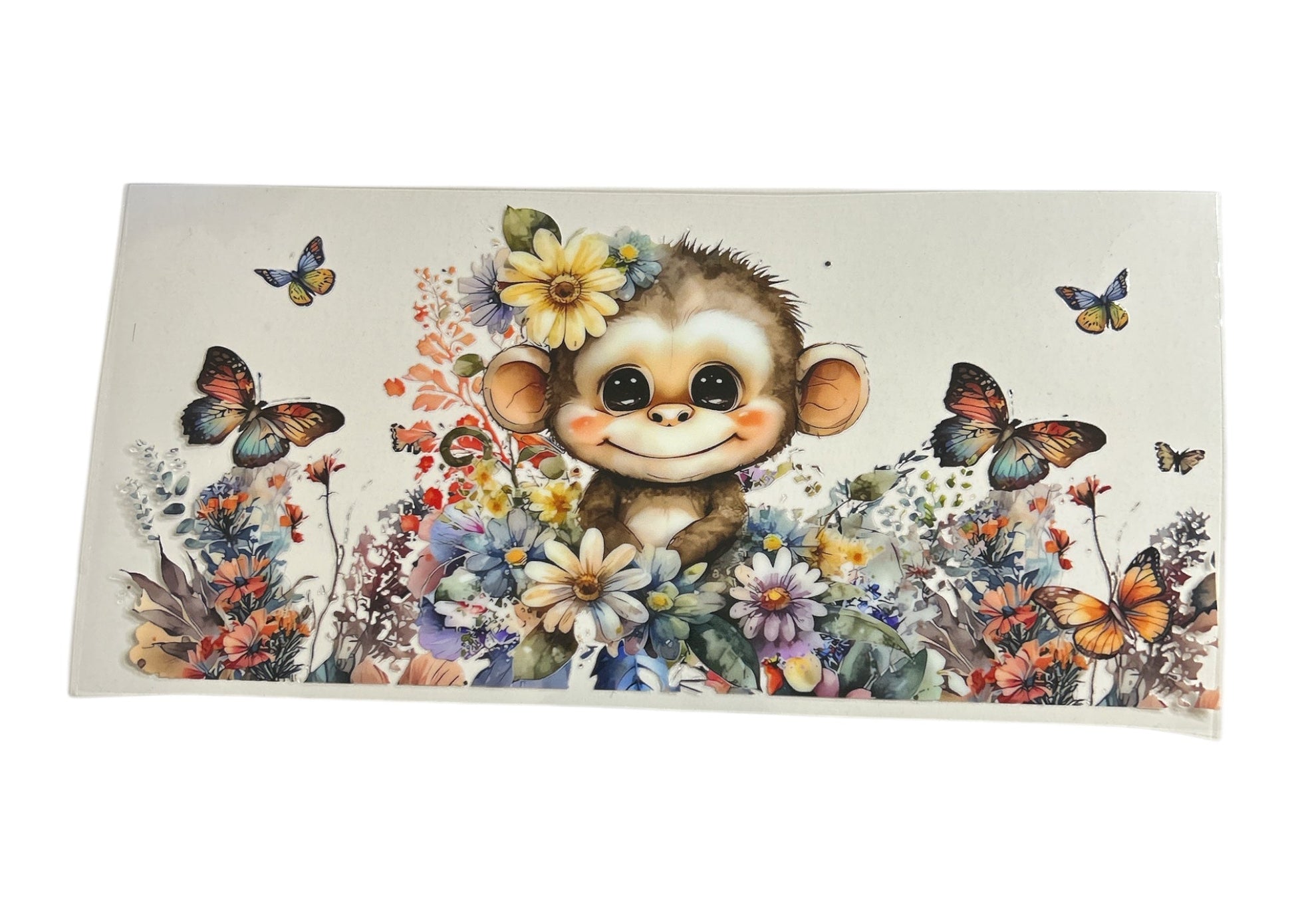 Watercolor-style cup wrap featuring a cute baby monkey with large eyes and a flower on its head, sitting in a dense field of colorful wildflowers with several butterflies fluttering around.