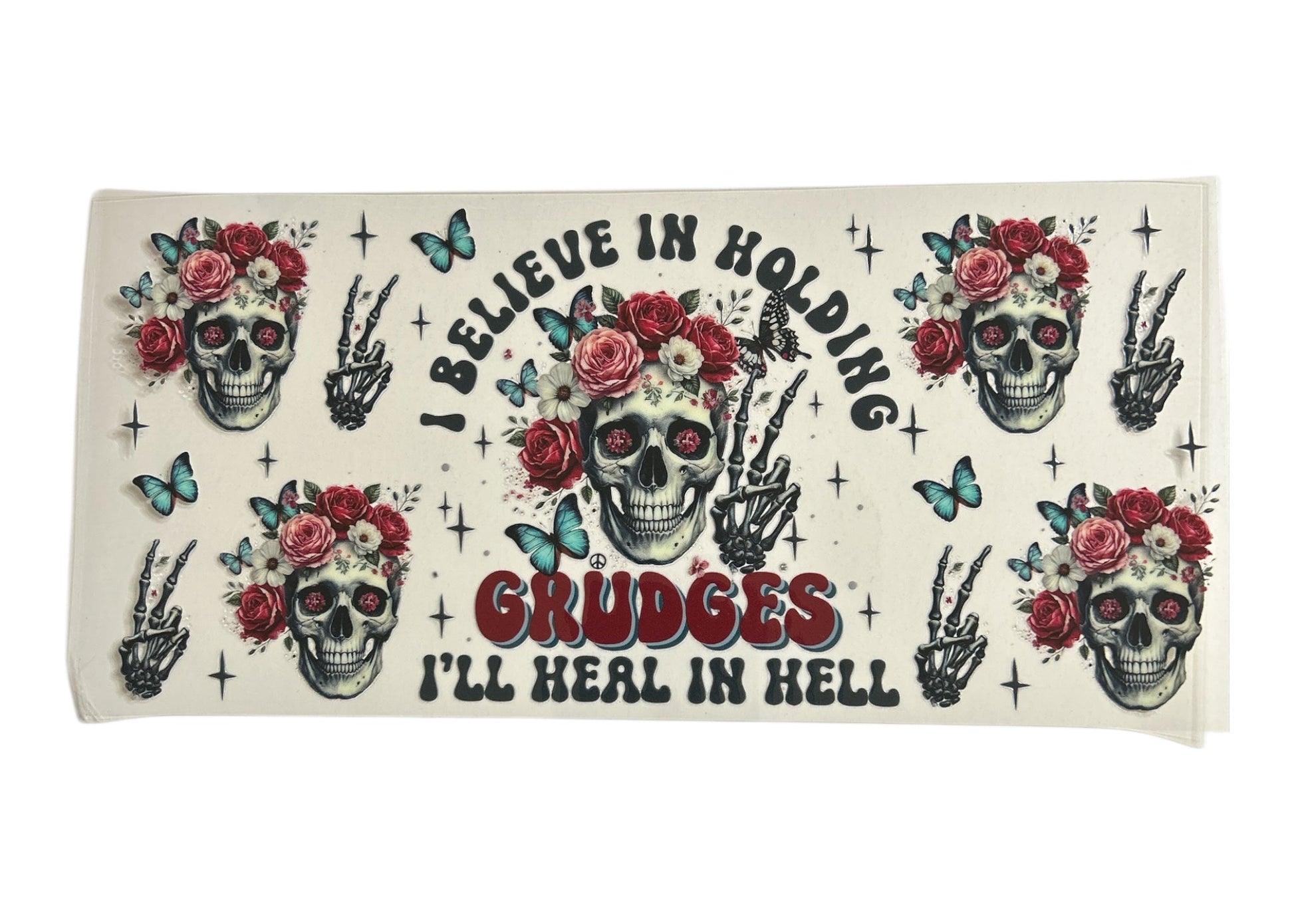 Cup wrap with skull designs, flowers, and text on a white background