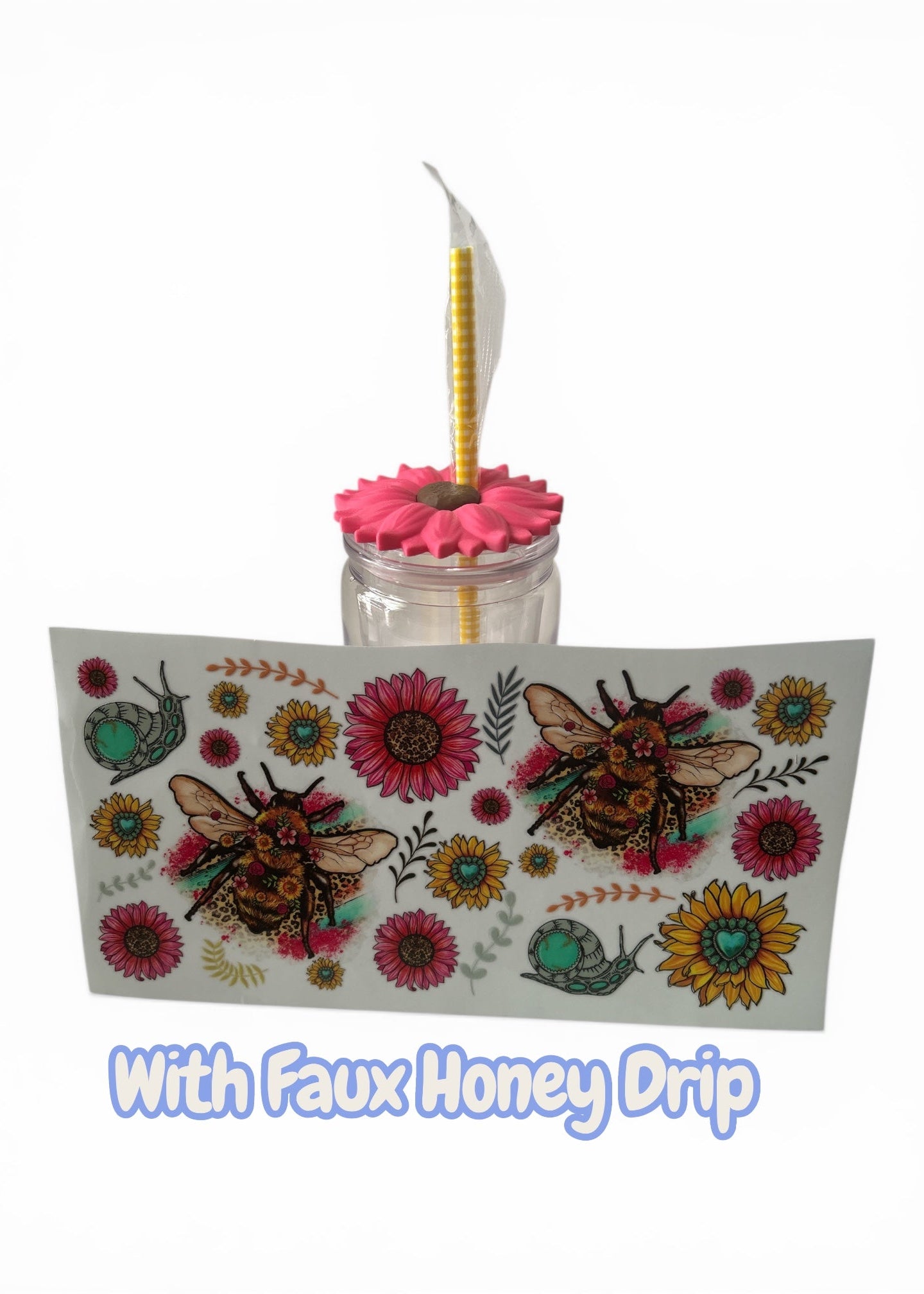 Decorative glass with pink flower and yellow straw, featuring bee and floral design on a white background.