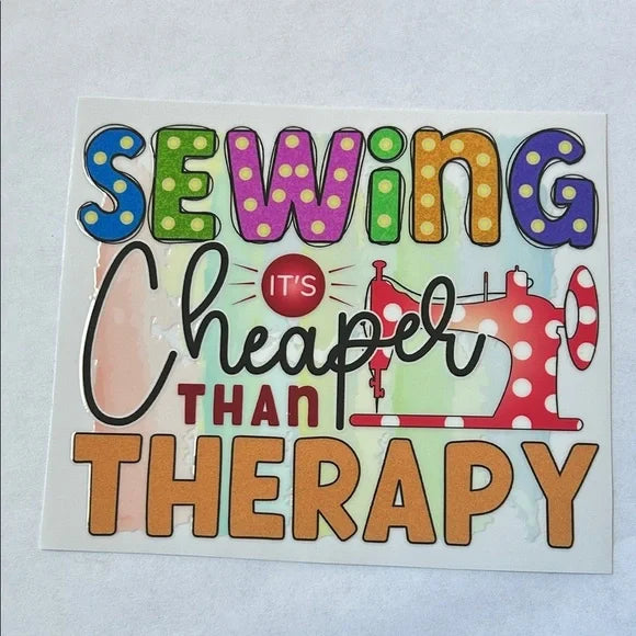 Colorful sign with text 'Sewing is cheaper than therapy' on a light gray background